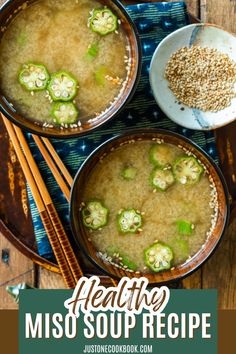 two bowls filled with miso soup and chopsticks on top of a wooden table