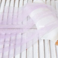 a teddy bear wearing a purple tulle on top of a white table