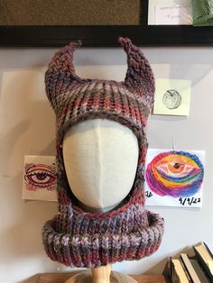 a mannequin's head wearing a knitted hat with horns on it