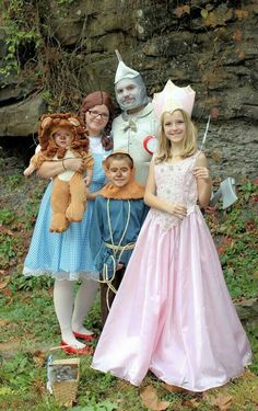 three children dressed up as wizard and princesses posing for the camera with their stuffed animals