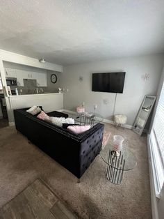 a living room filled with furniture and a flat screen tv mounted on the wall above it