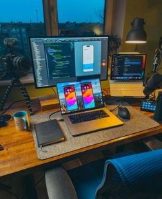 an open laptop computer sitting on top of a wooden desk next to a desktop computer