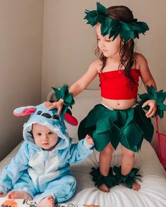 two children dressed up in costumes on a bed