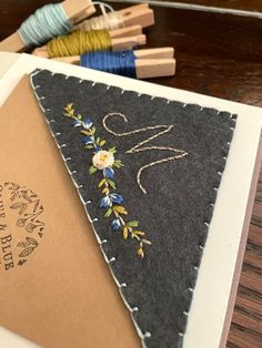 a close up of a piece of cloth on a table with some knitting needles in the background