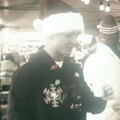 a man wearing a santa hat standing next to another man