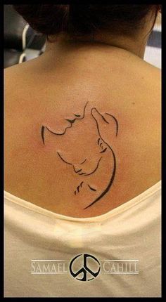 the back of a woman's neck with a dog tattoo on it