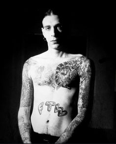 a man with tattoos on his chest and arms