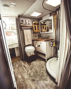 a bathroom with a toilet, sink and shower in the corner next to a window