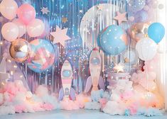 a space themed birthday party with balloons, stars and rocket ship on the stage backdrop