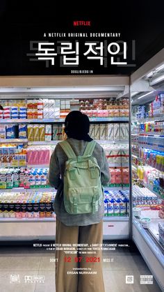 a woman standing in front of a store filled with drinks and juices on shelves