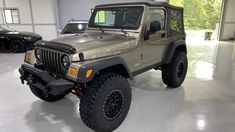 a jeep is parked in a garage with other cars