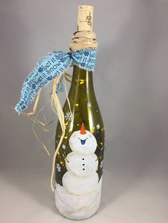 a bottle with a snowman on it and a blue ribbon tied around the top