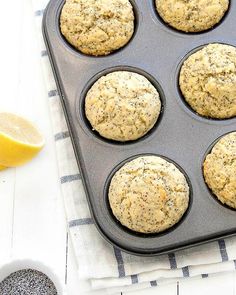 lemon poppy seed muffins in a muffin tin on a blue and white towel