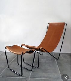 a pair of chairs sitting next to each other on a tile floor in front of a white wall