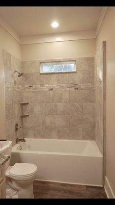 a white toilet sitting next to a bath tub in a bathroom