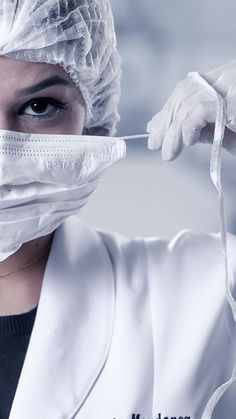 a woman in white lab coat and surgical mask