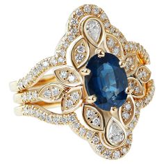 This engagement ring set is remarkable, featuring a center stone in the form of an oval-shaped blue sapphire - the traditional September birthstone - decorated with art nouveau leaf ornaments and two pear-shaped diamonds. This vintage-inspired lily flower royal engagement ring is paired with a diamond-accented contour ring guard wedding band. The lily flower, a timeless symbol of innocence, purity, and beauty, adds a sentimental touch to this must-have piece. The list is for the Engagement ring Blue Sapphire Ring Guard, Diamond Ring Guard, Royal Engagement Rings, Contour Ring, Flower Engagement, Leaf Ornament, Ring Guard, Timeless Symbol, Flower Engagement Ring