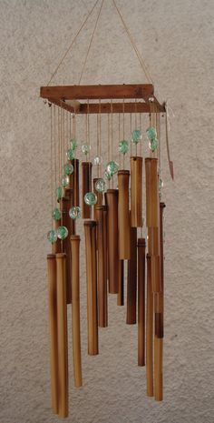 a wind chime hanging from the ceiling with beads and wood sticks attached to it