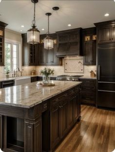 a large kitchen with dark wood cabinets and marble counter tops