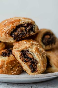 a white plate topped with pastries covered in raisins on top of a table