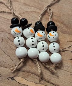 snowmen made out of eggs are sitting on a wooden table with string attached to them