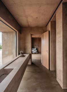 an empty room with concrete walls and floor to ceiling windows looking out onto the outdoors