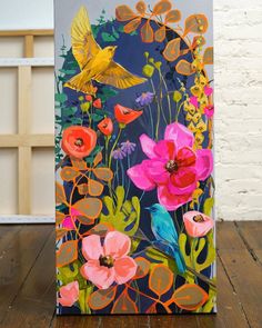 a painting on a wooden table with flowers and birds painted on it's side