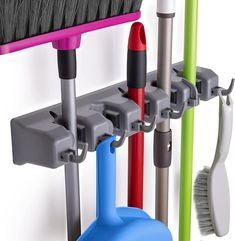 there are many different colored brooms and brushes in the holder on the wall next to each other