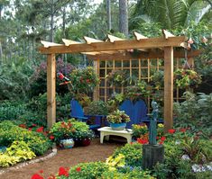 an outdoor garden with lots of flowers and plants around the area, including blue chairs