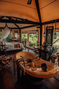 a large bath tub sitting on top of a wooden floor next to a bed in a bedroom