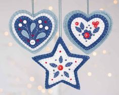 two blue and white heart shaped ornaments hanging from strings with lights in the back ground