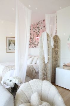 a bedroom with white bedding and curtains