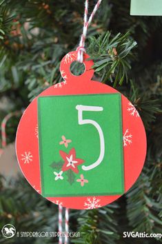 an ornament hanging from a christmas tree with the number five on it's front