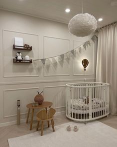 a baby's room with a white crib and wooden stools on the floor