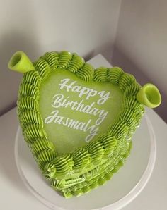 a heart shaped birthday cake with green icing