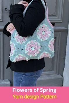 a woman holding a crocheted bag with flowers on it and the words flowers of spring written in pink