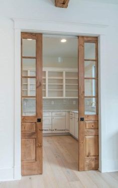 an open door leading to a kitchen with white cabinets