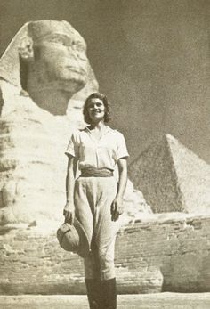 an old photo of a woman standing in front of the sphinx