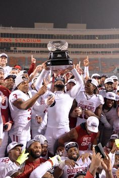 the stanford football team celebrates with the trophy after their win in the college football game