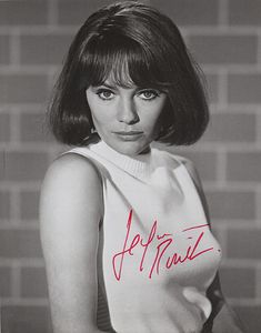 a black and white photo of a woman with short hair wearing a sweater that has the words p f m t n i z written on it