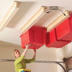 a woman is working on the ceiling in her room with red boxes attached to it