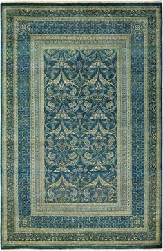 a blue and green rug with an intricate design on the center, surrounded by ornate borders