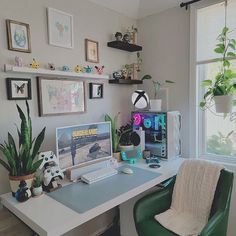 a desk with a computer and some plants on it