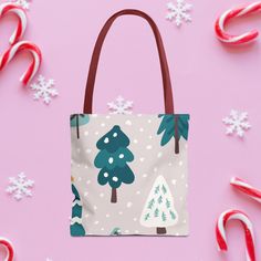 a handbag with christmas trees and candy canes around it on a pink background