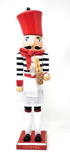 a wooden nutcracker with a red hat and scarf