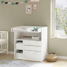 a baby's room with a crib, dresser and changing table in it