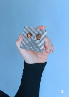 a person holding up a small box with two cookies in it's palm, against a blue background