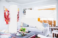 a living room filled with lots of furniture next to a wall covered in white paint