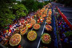 an aerial view of a parade with float's in the street and people watching