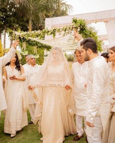 a bride and groom walking down the aisle at their wedding ceremony with guests in white outfits